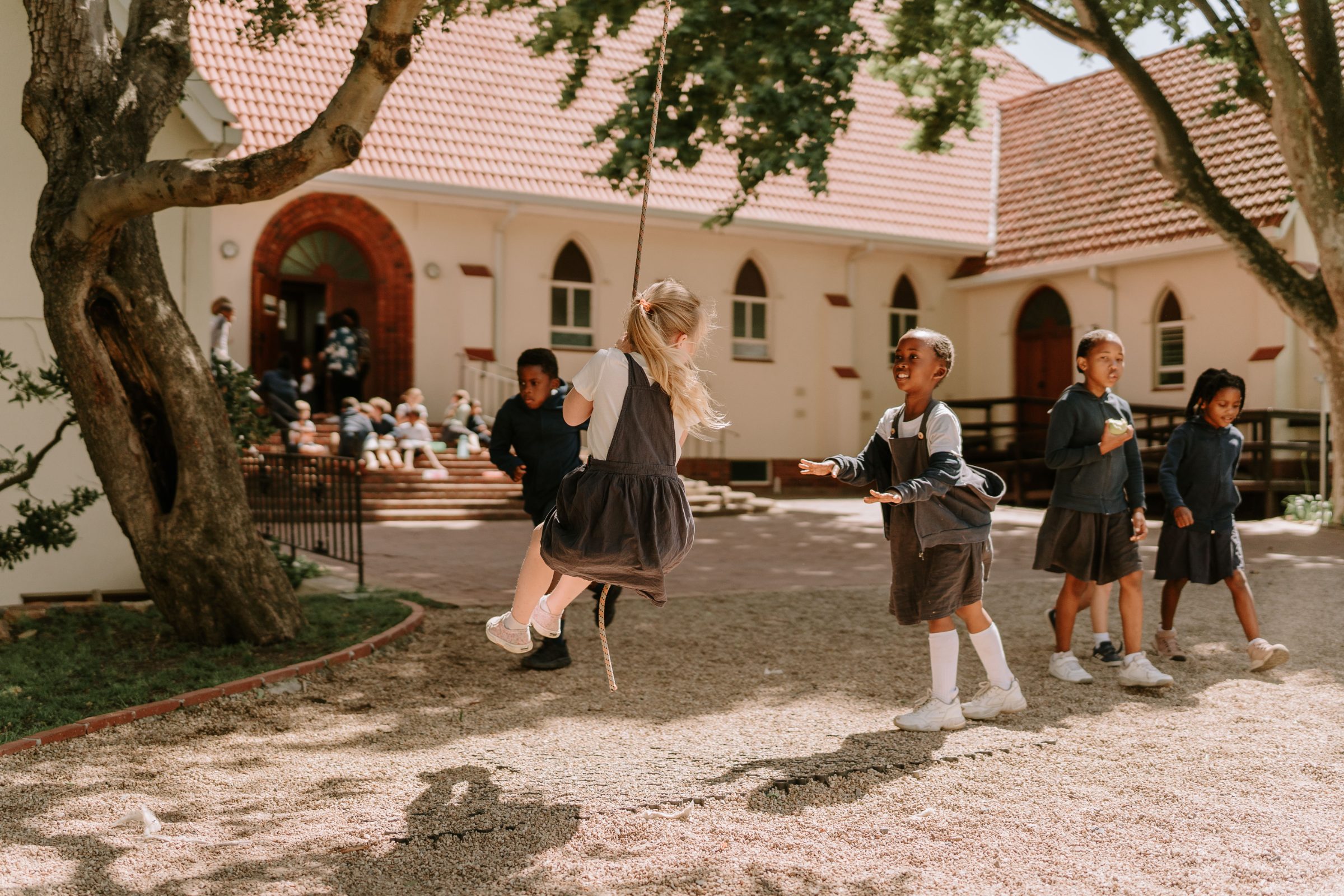 Children playing on the rope swing outside Three Peaks School
