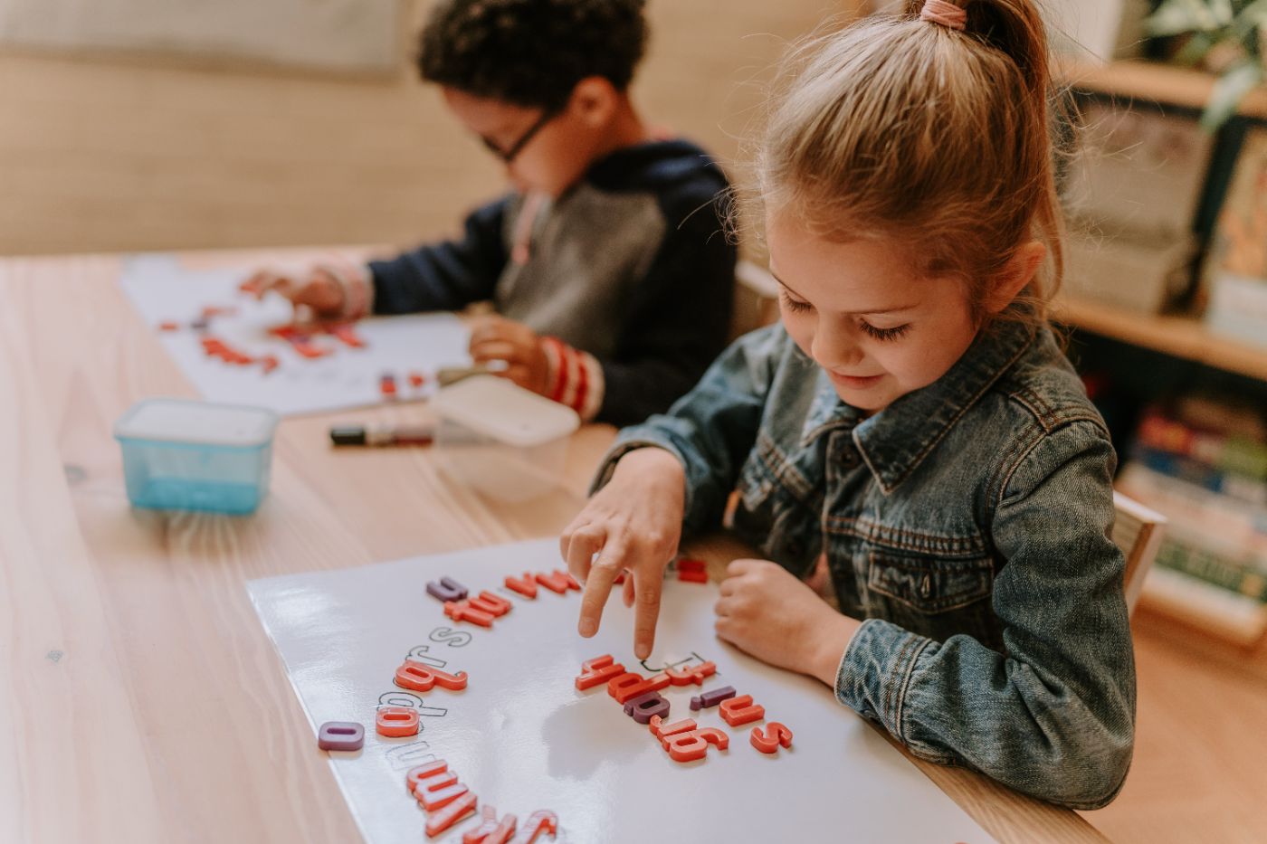 A girl building words with letter tiles in class